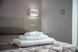 a stack of white towels on a bed