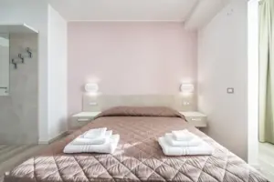 a bed with pink walls and a pink blanket